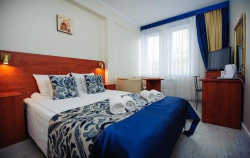 a hotel room with a bed with towels on it at Abidar Hotel Spa & Wellness in Ciechocinek