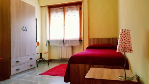 a bedroom with a red bed and a window at Casa Vacanze DaRena in Tortoreto Lido