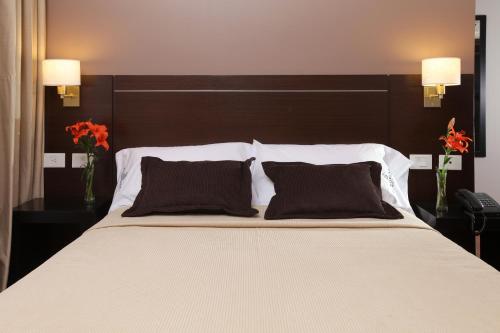 a bedroom with a large bed with two pillows at Europlaza Hotel & Suites in Buenos Aires