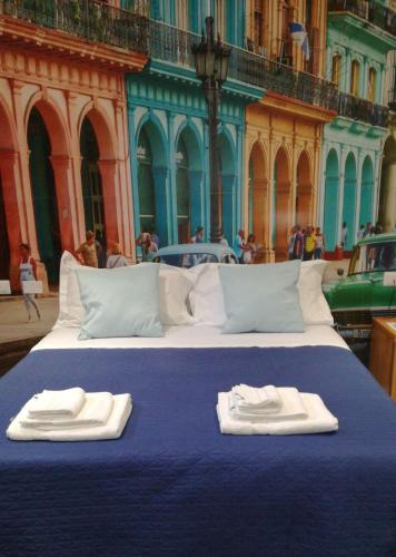 a blue bed with two towels on top of it at Palazzo al Carmine Dimora Storica in Castelvetrano Selinunte