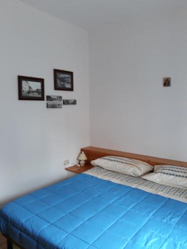 een bed in een kamer met twee foto's aan de muur bij Appartamento Guitgia in Lampedusa