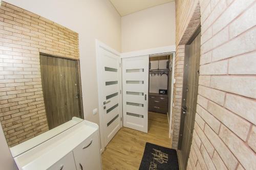 a bathroom with white walls and a brick wall at Family Apartment in Odesa