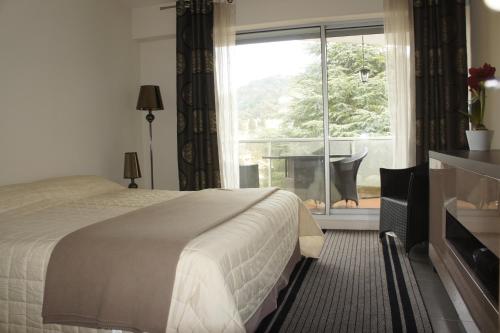 um quarto com uma cama, uma janela e uma secretária em Sea view Penthouse with terrace em Cannes