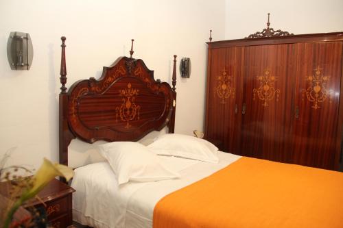 a bedroom with a bed and a dresser at Monte Sinai Guest House in Porto