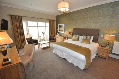 a bedroom with a large bed and a living room at Beech Hill Hotel & Spa in Windermere