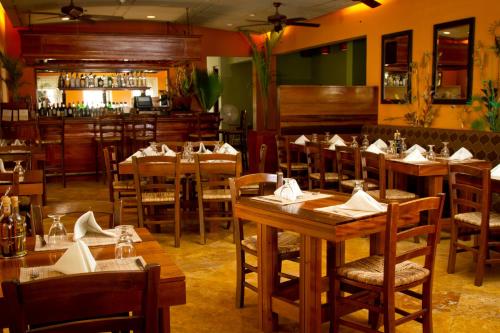 a restaurant with wooden tables and chairs and a bar at The Crane Resort in Saint Philip