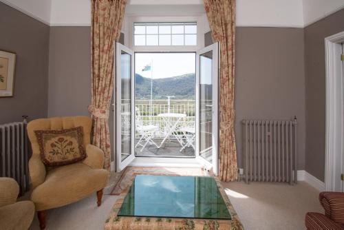 a living room with a couch and a glass table at Plas Maenan in Conwy