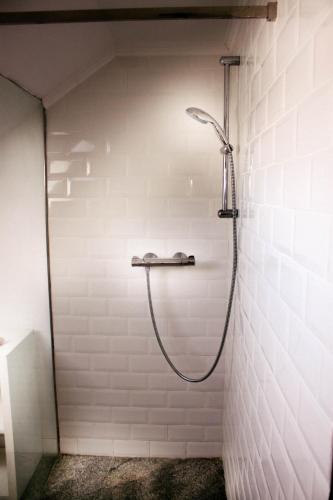 a shower in a white tiled bathroom at Cotton Loft in Alba Iulia