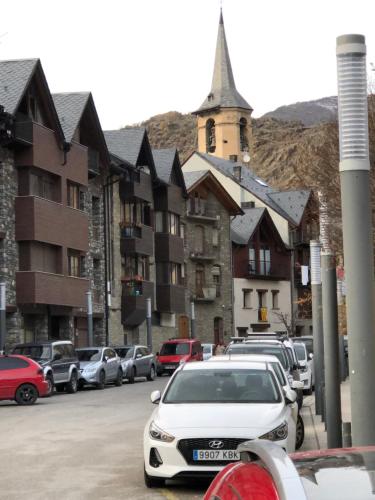 a parking lot with cars parked in front of a building at Apartament Valls d'Aneu in Esterri d'Àneu