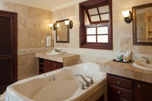 a large bathroom with a tub and a sink at The Crane Resort in Saint Philip