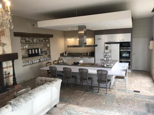 a kitchen with a large white island in a room at L'Orangerie de Camperos in Barsac