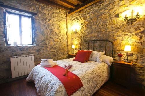 a bedroom with a bed in a stone wall at Agroturismo Izarre in Errezil