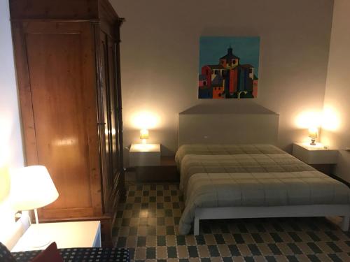 - une chambre avec un lit et deux lumières sur deux tables dans l'établissement Casa Vacanze Pizzicantò, à Irsina