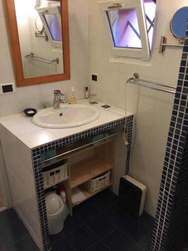 La salle de bains est pourvue d'un lavabo et d'un miroir. dans l'établissement Chez Régine et Serge, à Bandol