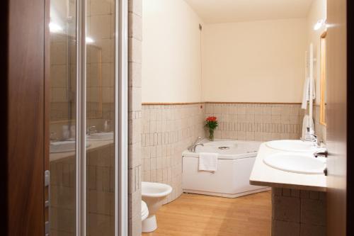 e bagno con servizi igienici, lavandino e doccia. di Hotel Del Parco a Vigevano
