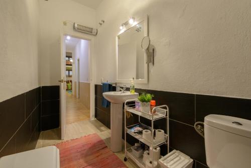 łazienka z umywalką, lustrem i toaletą w obiekcie RC Sevilla Centro Histórico CatedralJudería w Sewilli