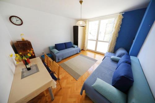 a living room with a blue couch and a table at Sea Organ Apartment 1 & Garage for Free - Oldtown in Zadar