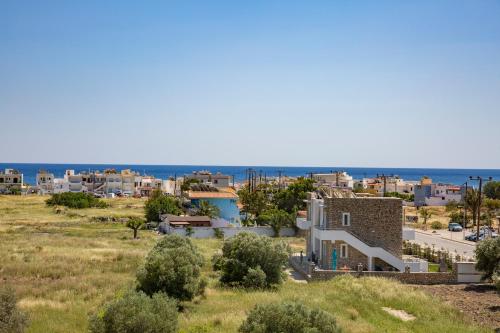 a view of a town with the ocean in the background at Haraki Stone Apartments in Haraki