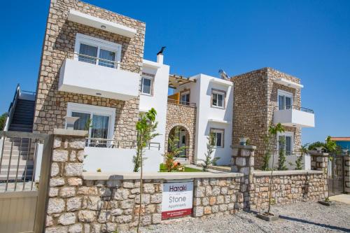 a villa with a stone fence in front of it at Haraki Stone Apartments in Haraki