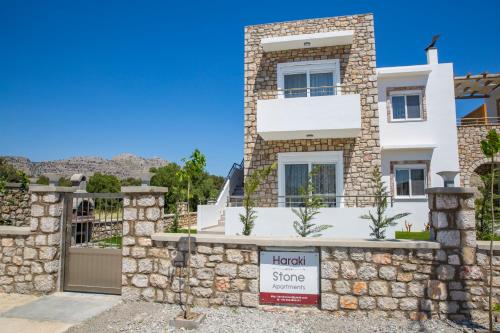 a house with a sign in front of it at Haraki Stone Apartments in Haraki
