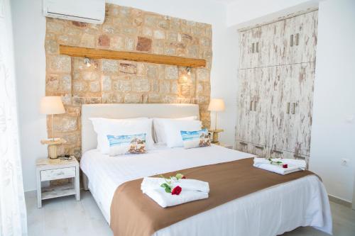 a bedroom with a large bed with towels on it at Haraki Stone Apartments in Haraki