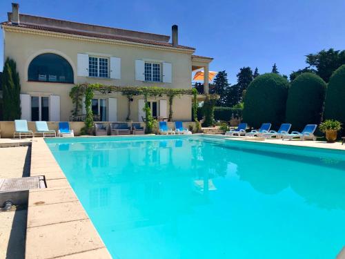 une piscine devant une maison dans l'établissement Le clos des vergers, à LʼIsle-sur-la-Sorgue