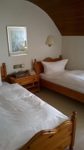 a bedroom with two beds and a picture on the wall at Hotel Alte Post in Wangen im Allgäu