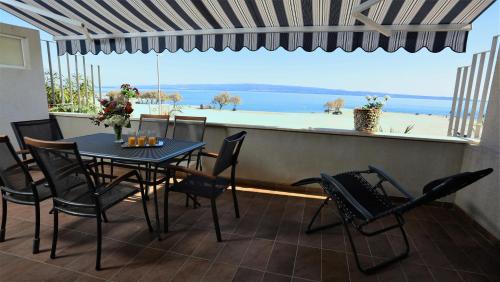 a table and chairs on a balcony with a view of the ocean at Apartman Lucita in Split