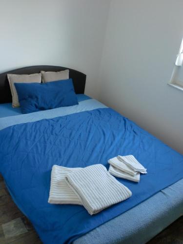 a bed with blue sheets and folded towels on it at Villa Santa Barbara in Vrsi