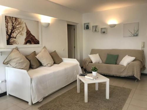 a living room with a white couch and a table at Vilamoura Cosy Central Flat in Vilamoura