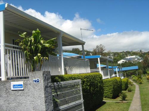 a house with a gate and bushes in front of it at Les Bungalows du Mont-Auban in Sainte-Clotilde