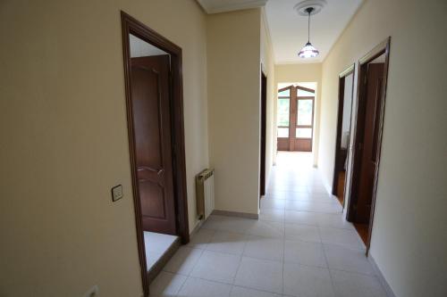 an empty hallway with a door and a mirror at La Nogalera in Nueva de Llanes