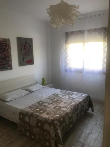 a bedroom with a bed and a window at Casa Pineta in Lido di Jesolo