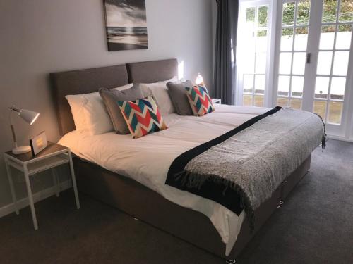 a bedroom with a large bed with a large window at The Garden Apartment in Leamington Spa