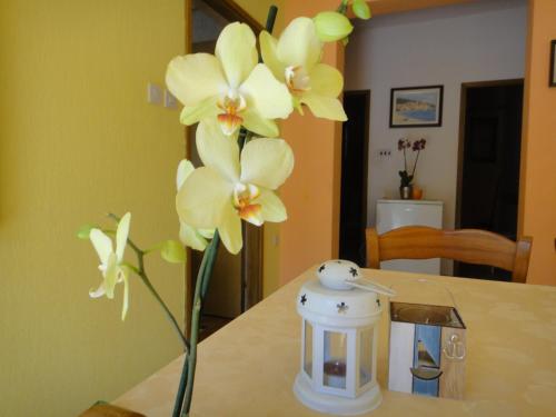 eine Vase mit gelben Blumen auf einem Tisch in der Unterkunft Apartman Vera in Mošćenička Draga