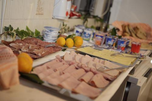a table with meat and other foods on a counter at Apartments and Rooms Deskovic in Mošćenička Draga