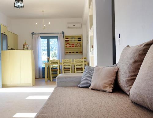 a living room with a couch and a dining room at Flora Apartments in Drios