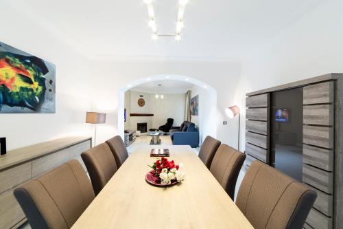 uma sala de jantar com mesa e cadeiras em The Queen Luxury Apartments - Villa Cortina em Luxemburgo
