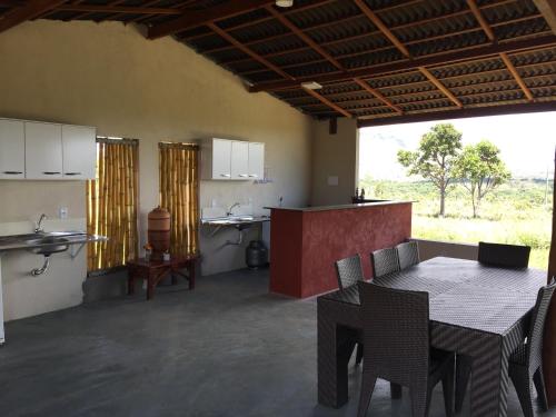 una cucina e una sala da pranzo con tavolo e sedie di Mirante do Morro a Alto Paraíso de Goiás