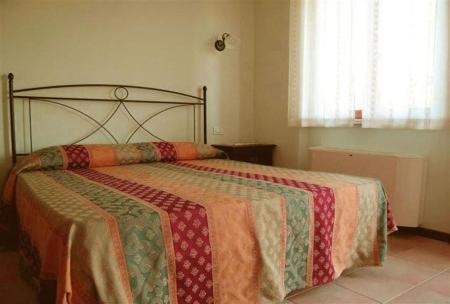 una camera con un letto con una trapunta sopra di B&B La Tenuta del Conte a Fermo