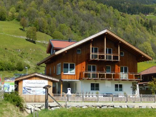 a large wooden house with a balcony on it at ff Appartements in Bramberg am Wildkogel