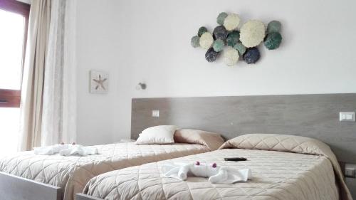 - 2 lits dans une chambre avec des serviettes dans l'établissement B&B Campu Moru, à Bari Sardo