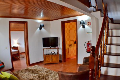 a living room with a staircase and a television at LAGOON'S HOUSE in Sete Cidades