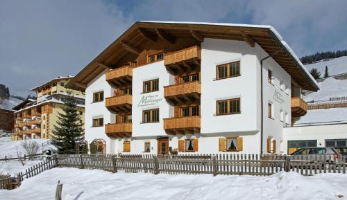 a building in the snow with a fence at Haus am Mühlanger in Serfaus