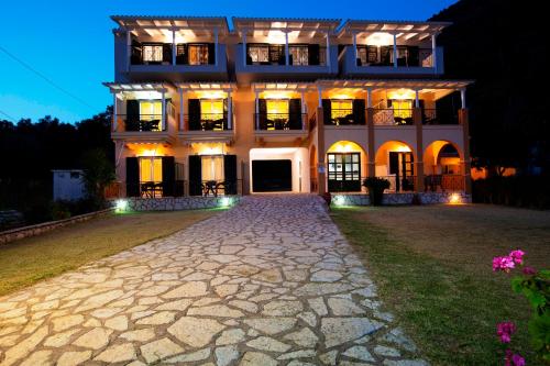 a large house at night with a cobblestone driveway at Captain Nick Aparthotel in Mikros Gialos