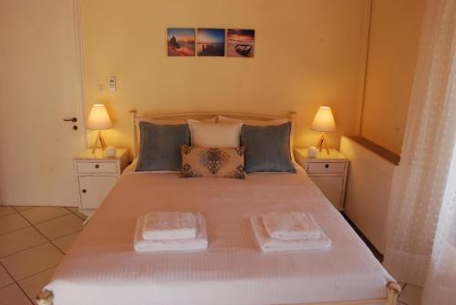 1 dormitorio con 1 cama blanca grande y 2 lámparas en Alexandra' s Village House, en Kato Korakiana