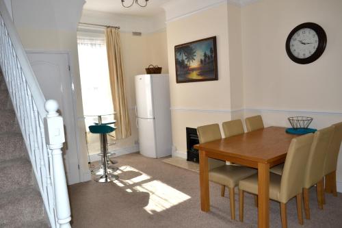 a dining room with a table and a refrigerator at Seam Terrace - Home from Home in Sittingbourne