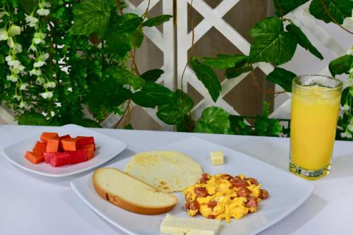 a table with two plates of food and a glass of orange juice at Hotel Florida Sincelejo in Sincelejo
