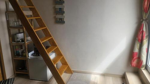 a wooden ladder in a room with a wall at Chambre direct piscine in Talence