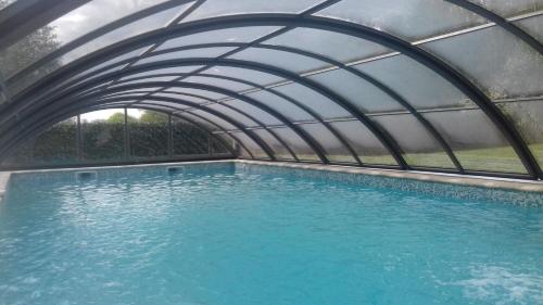 une piscine intérieure avec une arche sur l'eau dans l'établissement Chateau de la Lucazière, à Mont-Saint-Jean